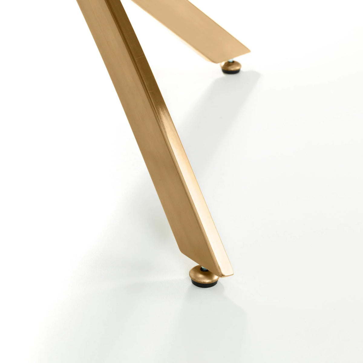 Gold metal table leg with protective foot detail on white background
