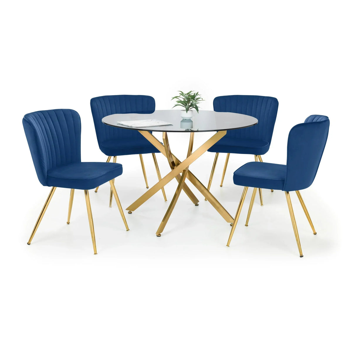 Glass dining table with gold legs and four blue velvet chairs, plant centerpiece