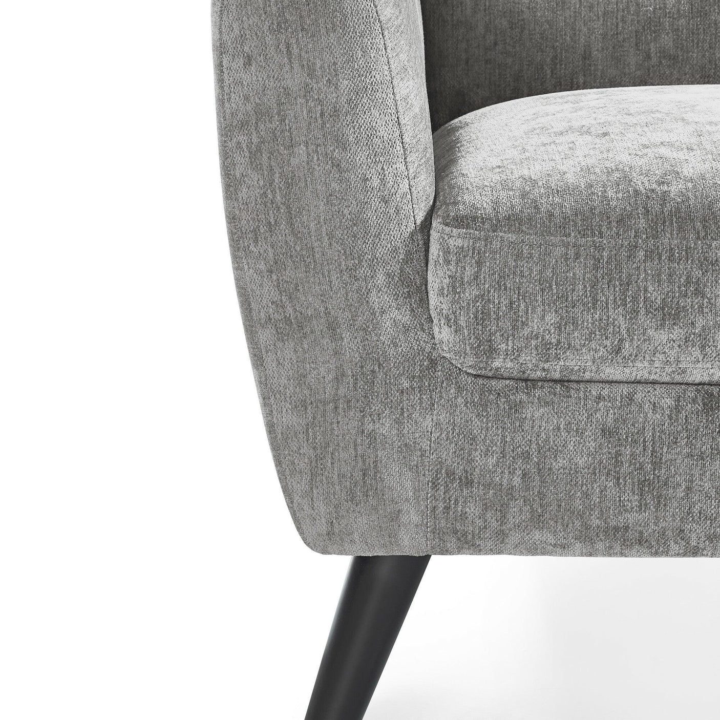 Close view of grey fabric armchair with tapered black leg and curved armrest