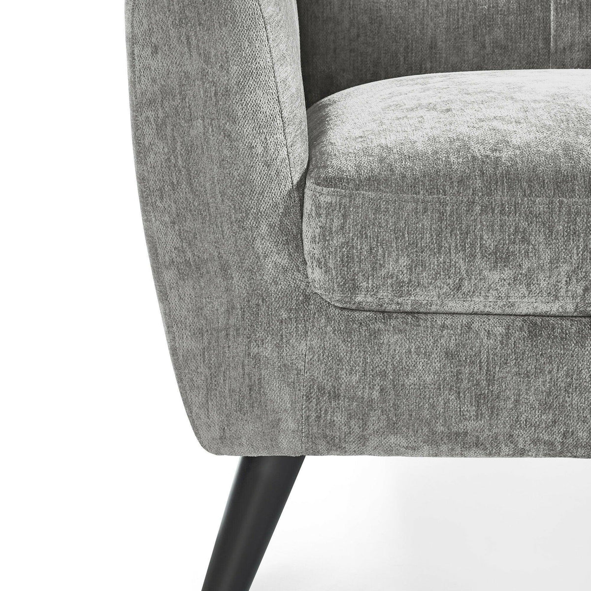 Grey fabric armchair close-up showing rounded armrest, cushioned seat and black wooden leg