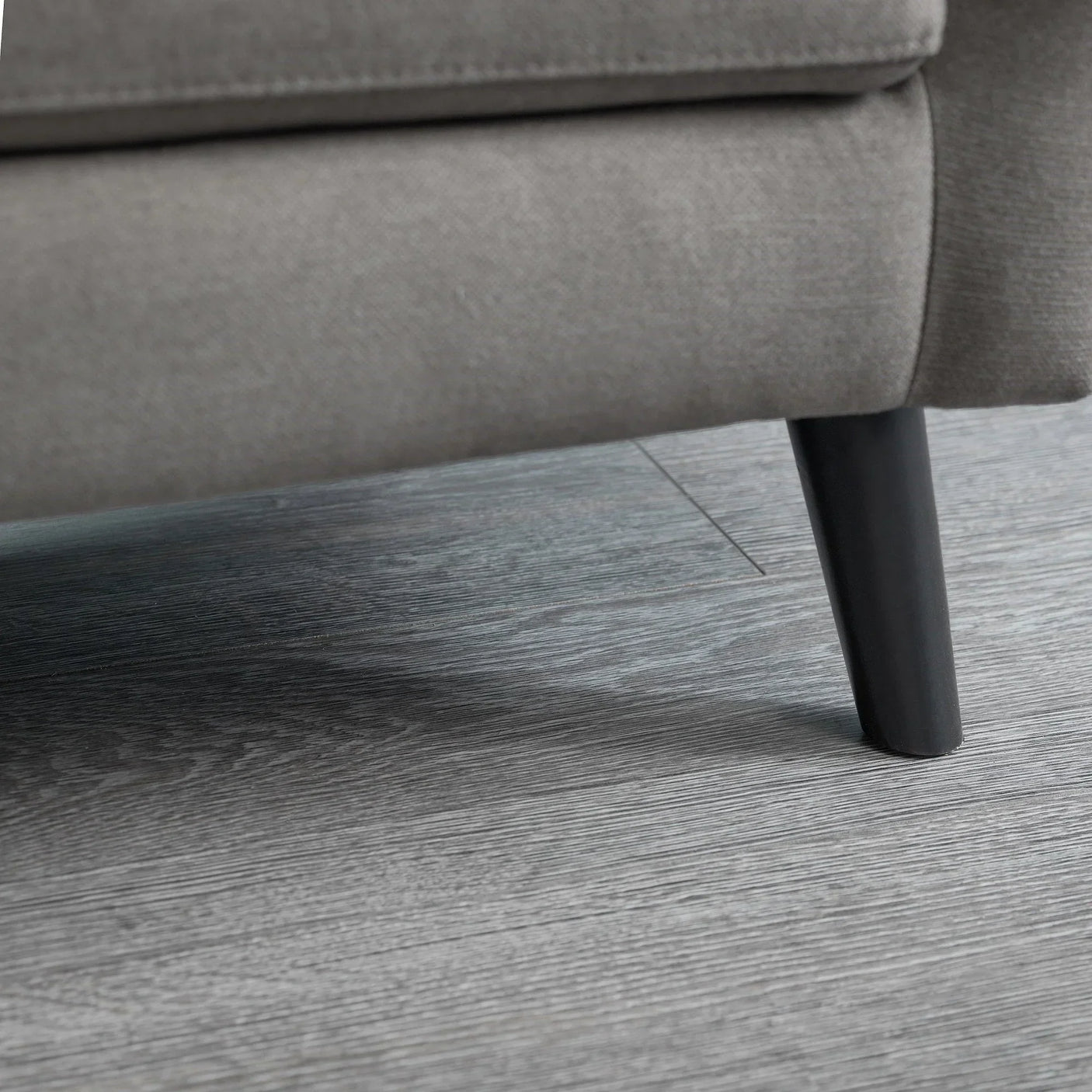 Grey sofabed fabric and black tapered leg detail on wood flooring