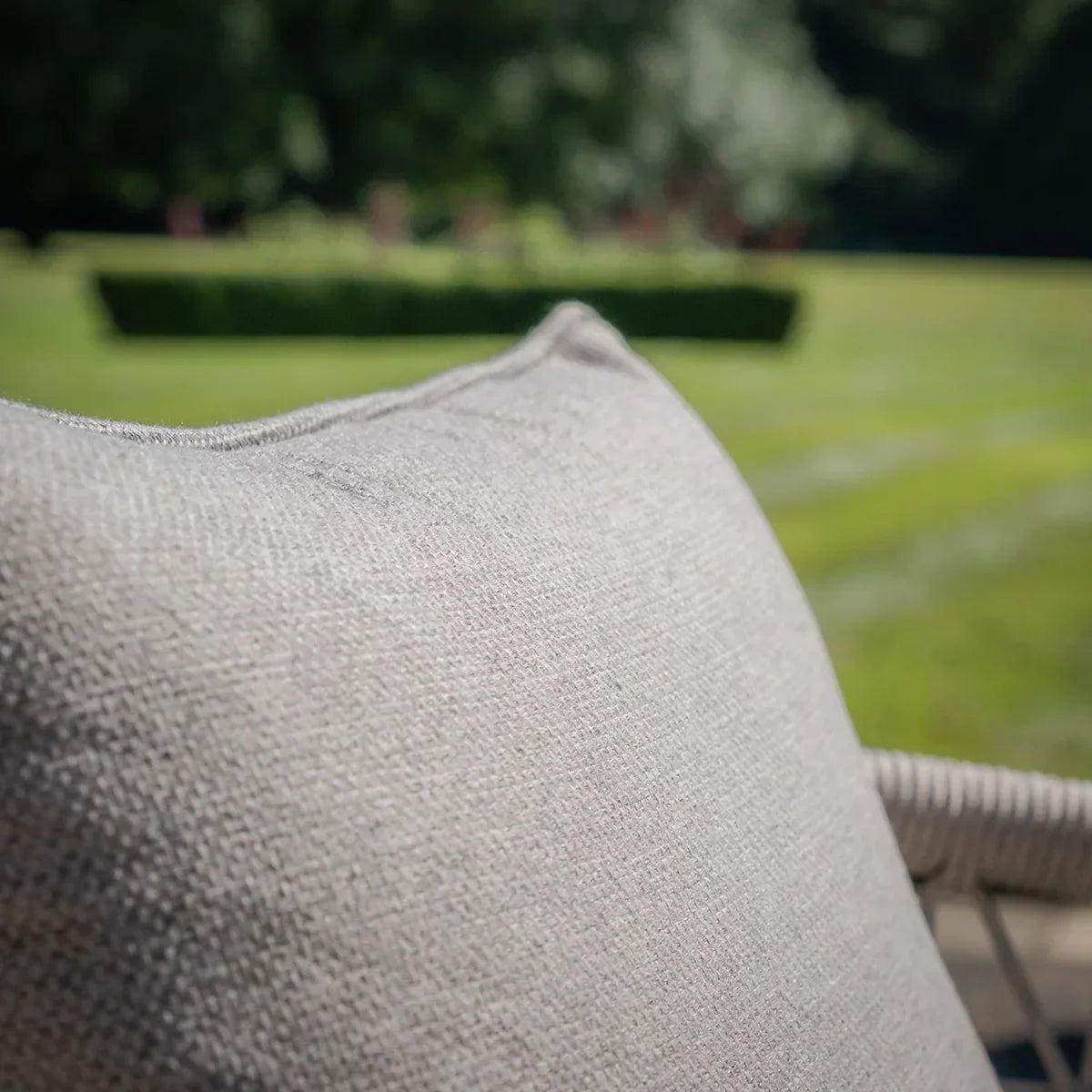 Closeup of outdoor sofa set grey cushion texture with garden view in background