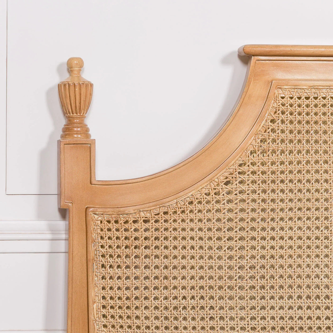 Natural wood headboard with woven rattan panel in close-up view