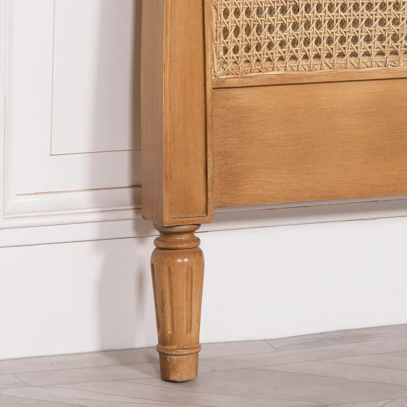 Natural wood bed frame with turned leg and woven rattan panel detail