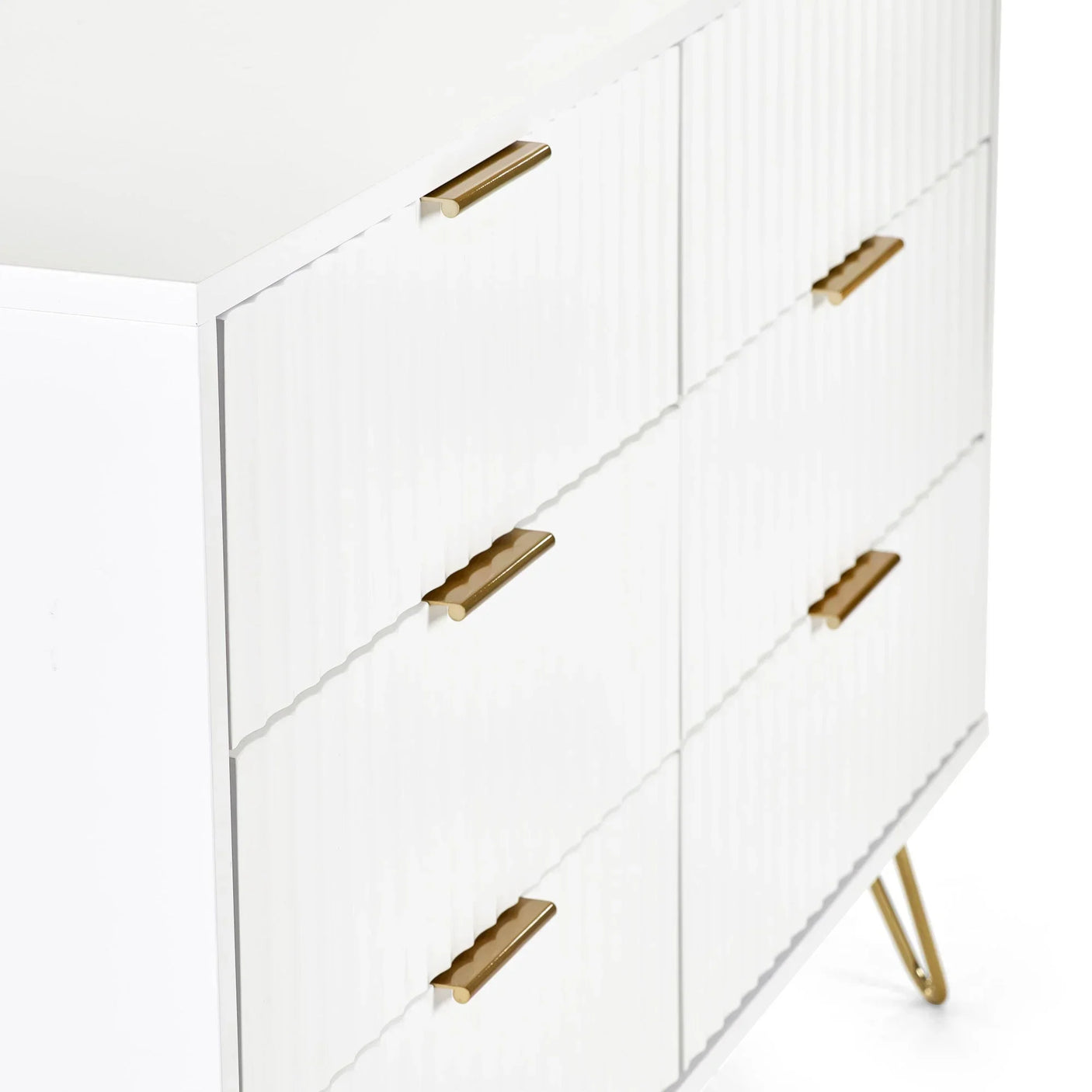 White chest of drawers with gold handles and angled legs, close side view