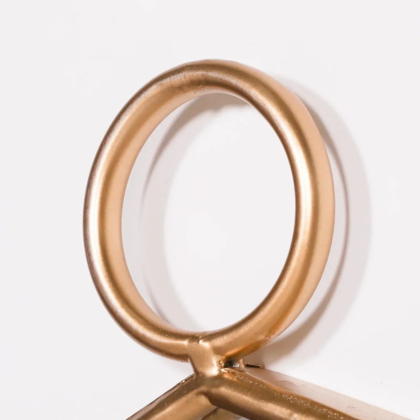 Metal gold ring detail on modern furniture frame against white background