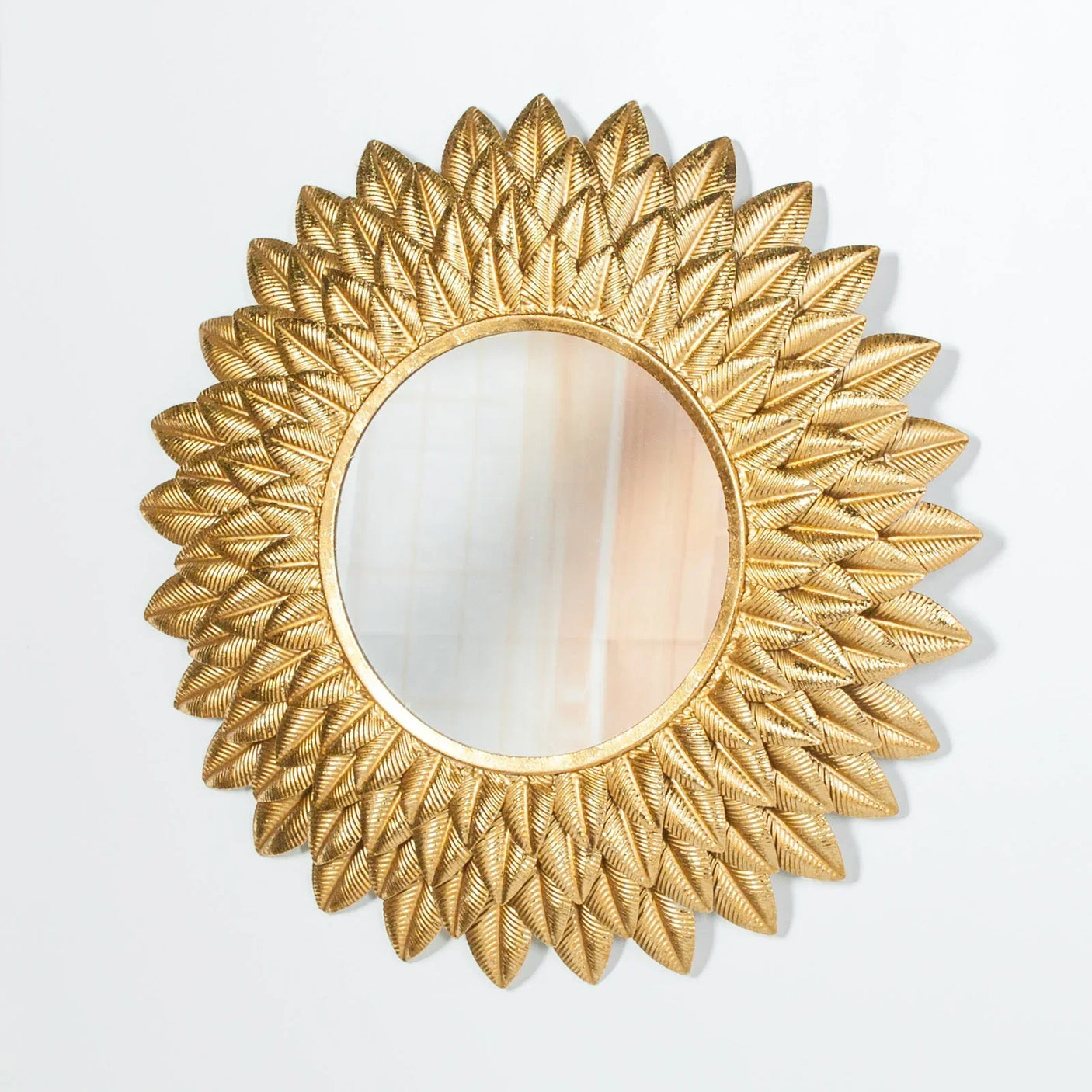 Gold sunburst wall mirror with textured leaf pattern frame