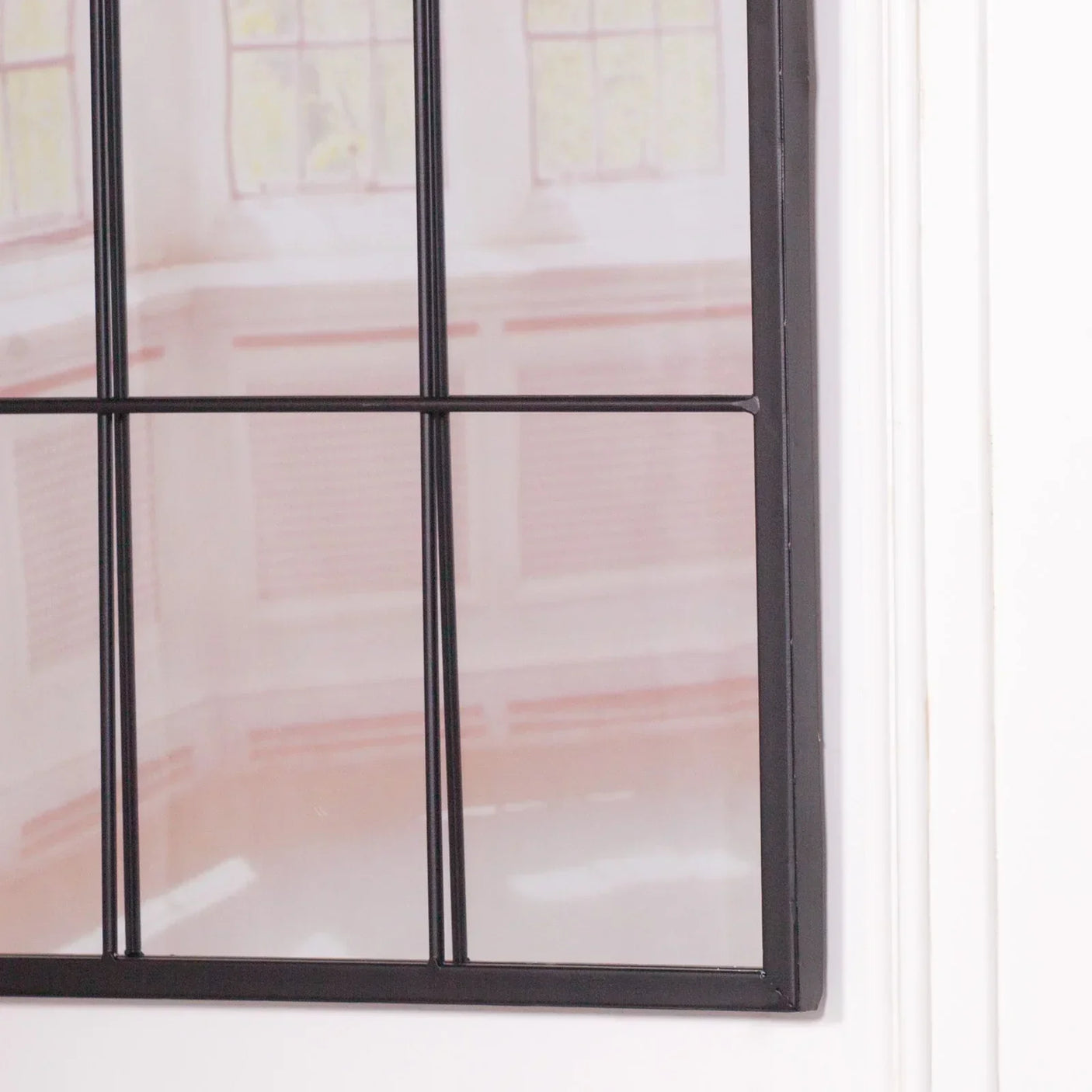 Black metal frame wall mirror with grid design close up