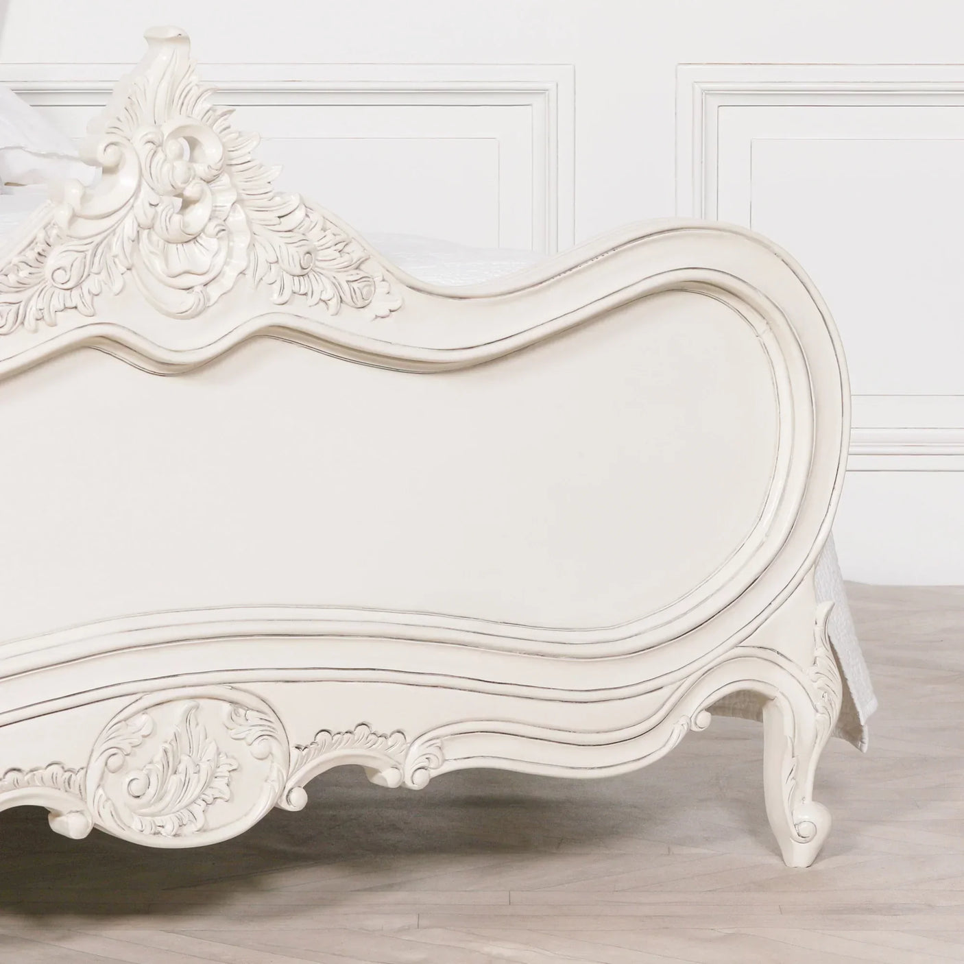 Cream French style bed frame with ornate carved detailing and curved footboard