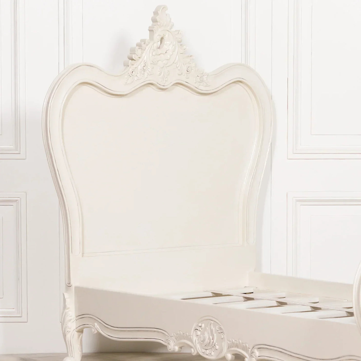 Cream wooden bed frame with ornate carved headboard and footboard detailing