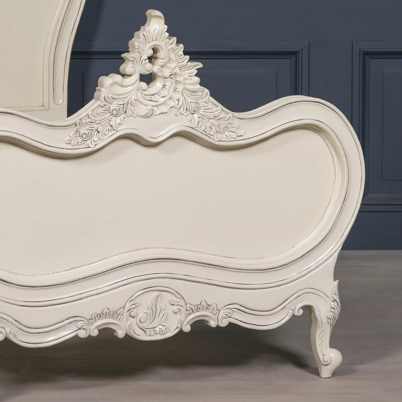 Cream French style bed frame with carved wood detail and curved footboard