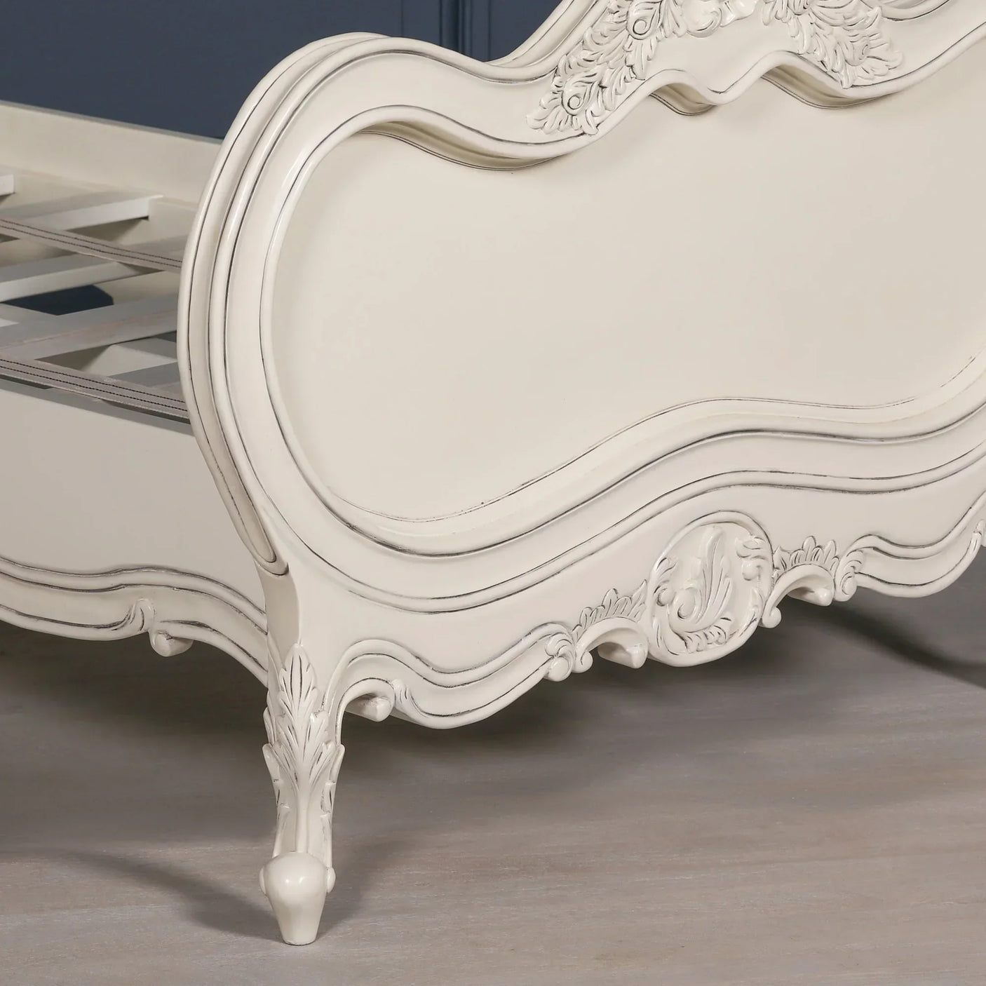 Cream painted wooden bed frame with ornate carved footboard and cabriole legs