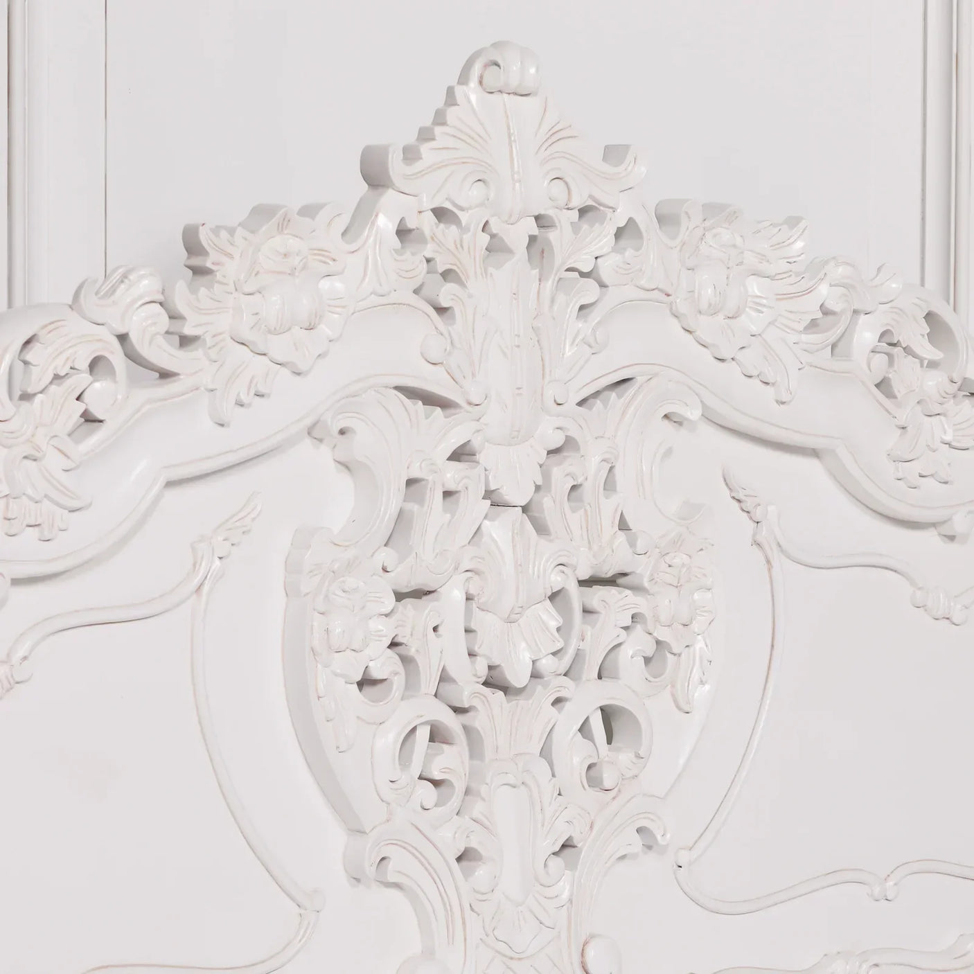 White carved wooden headboard with ornate floral detailing and traditional scrollwork