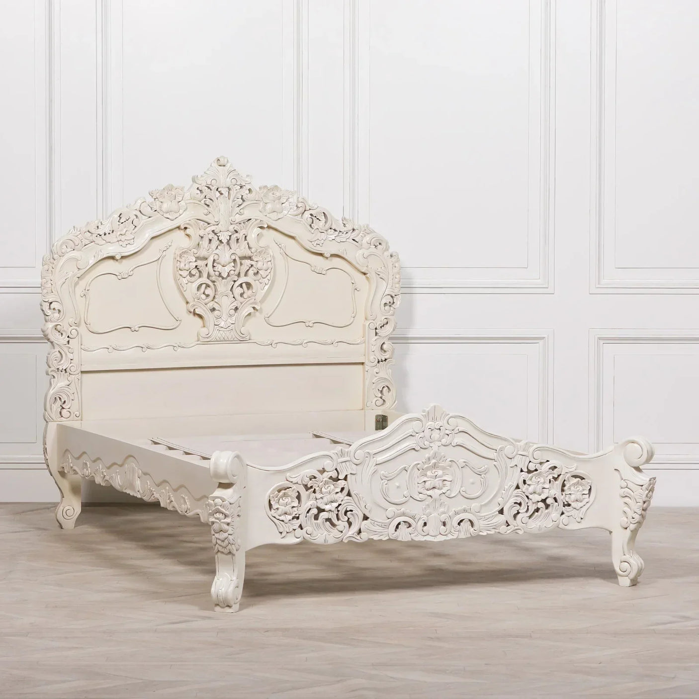 Ornate white carved wooden bed frame with intricate headboard and footboard detailing