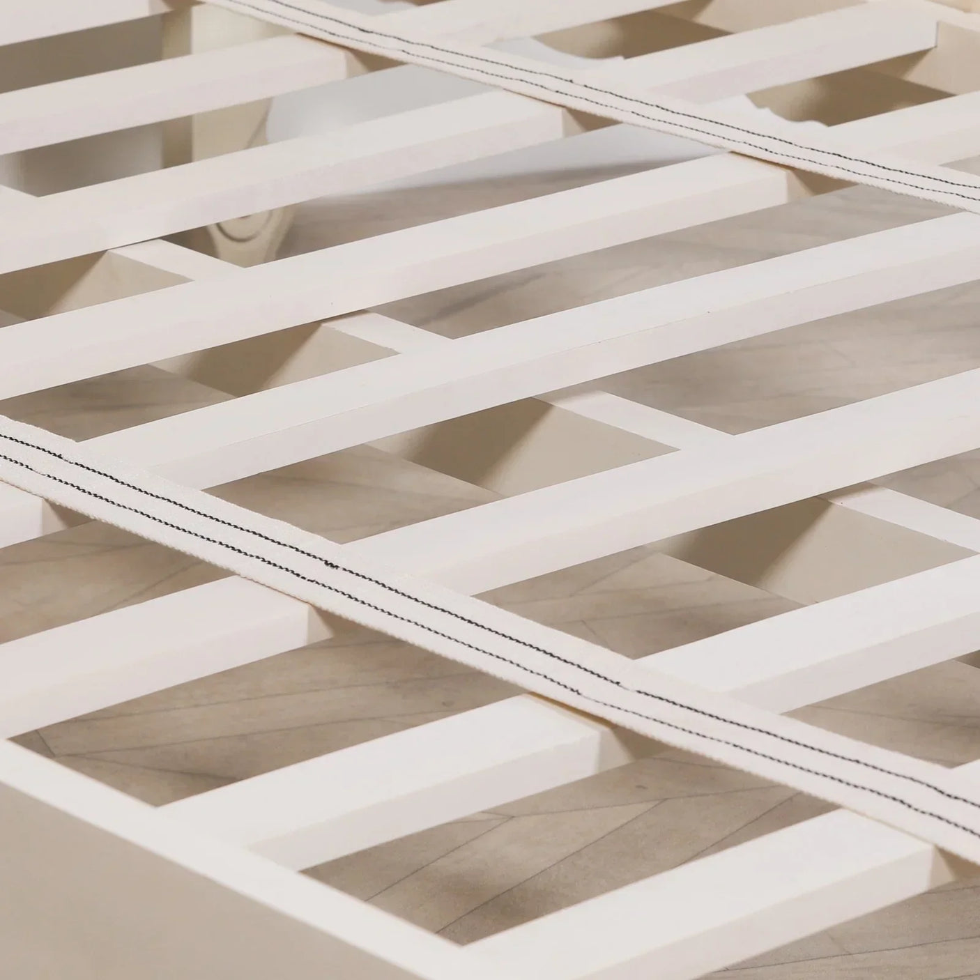 White wooden bed frame slats with fabric support straps, close-up view