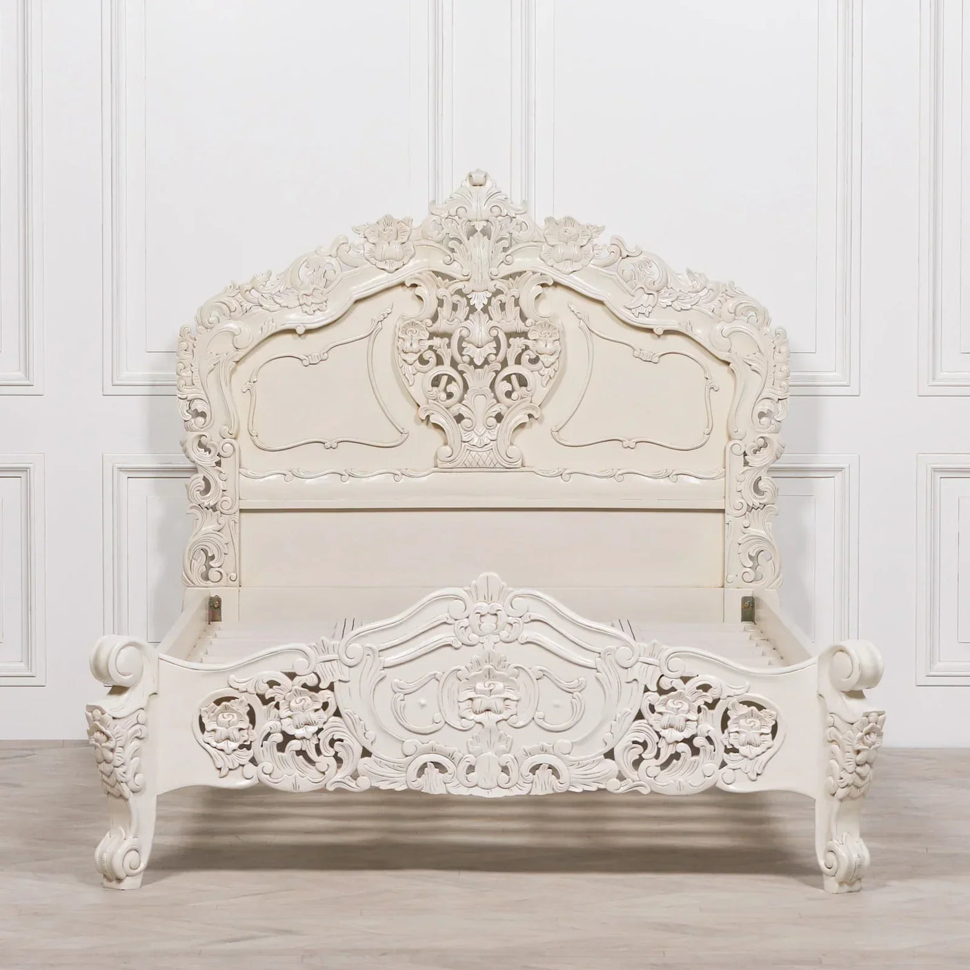 Ornate carved wood bed frame in white finish with detailed floral patterns and high headboard