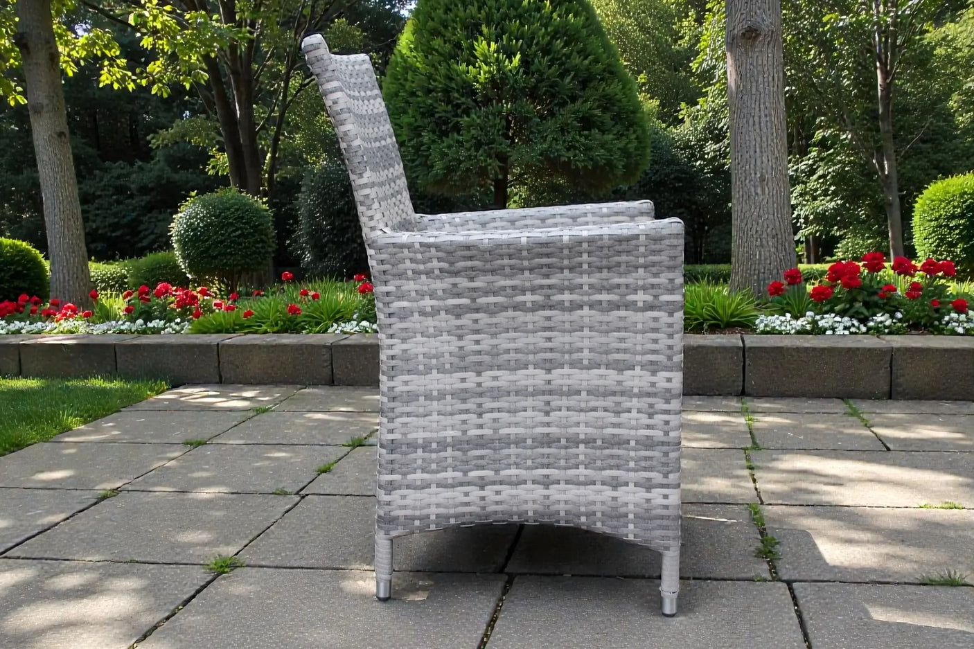 Grey rattan dining chair side view on patio with garden background