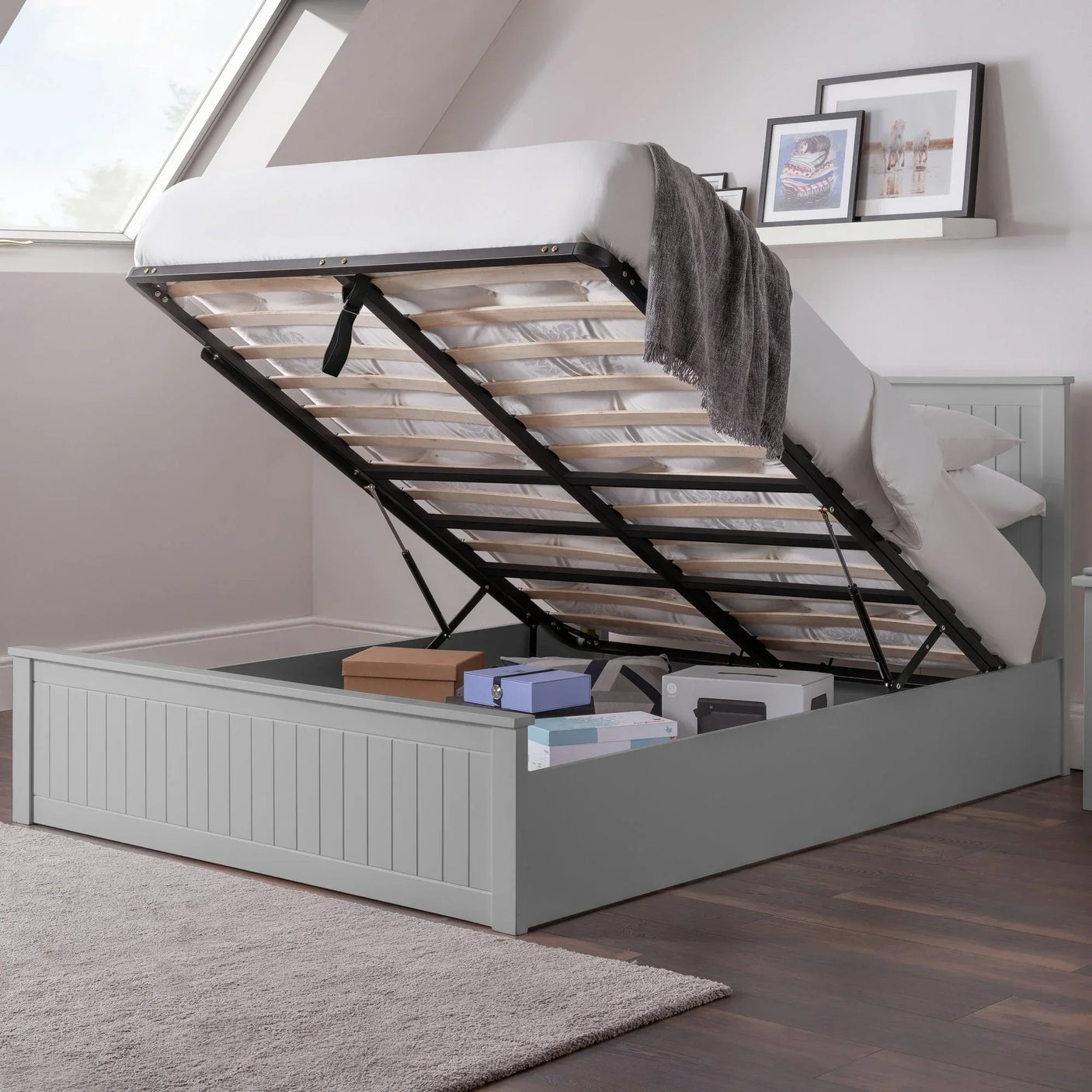 Dove grey ottoman bed open showing underbed storage with boxes in modern bedroom