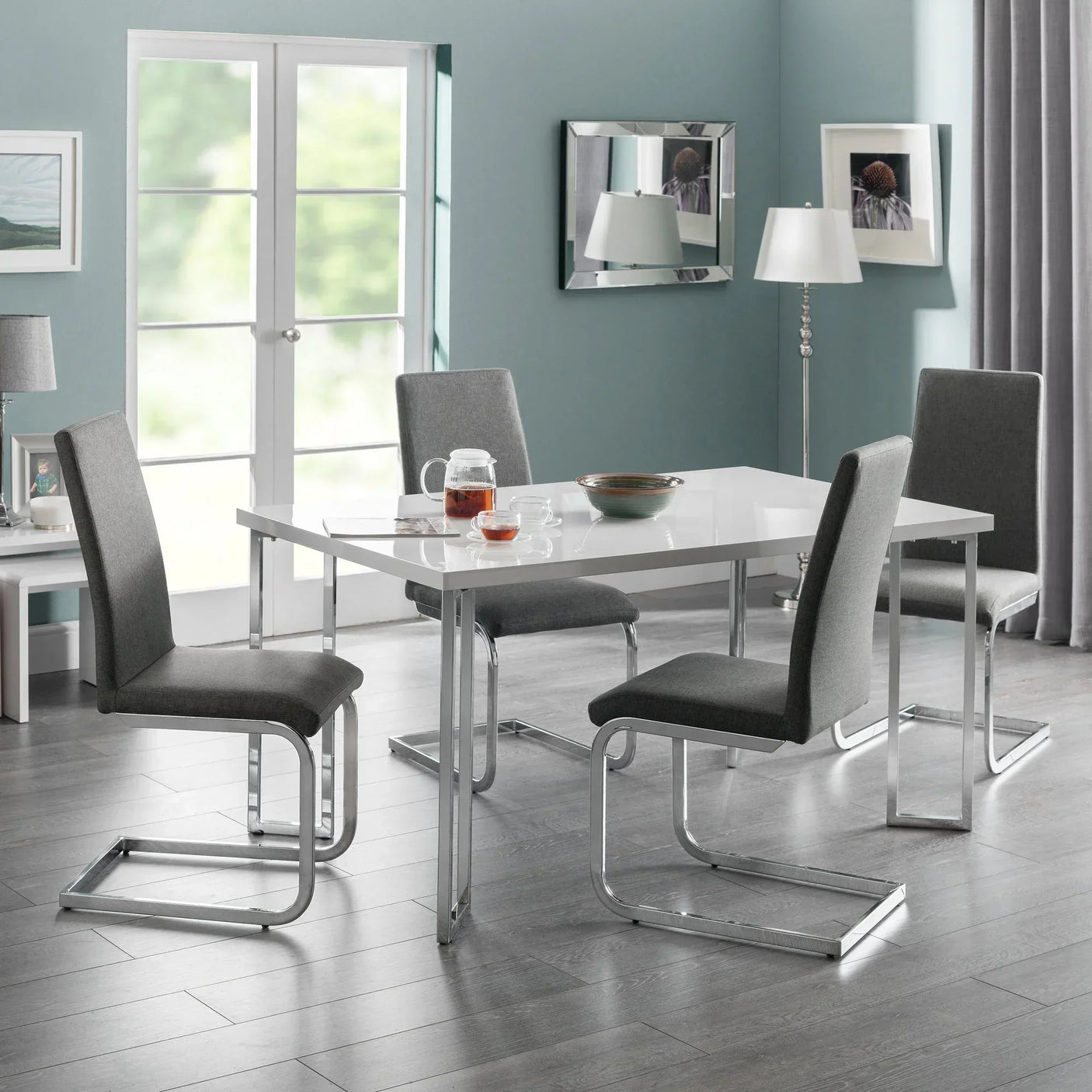 Gloss white dining table with chrome legs and four grey Roma chairs in modern dining room