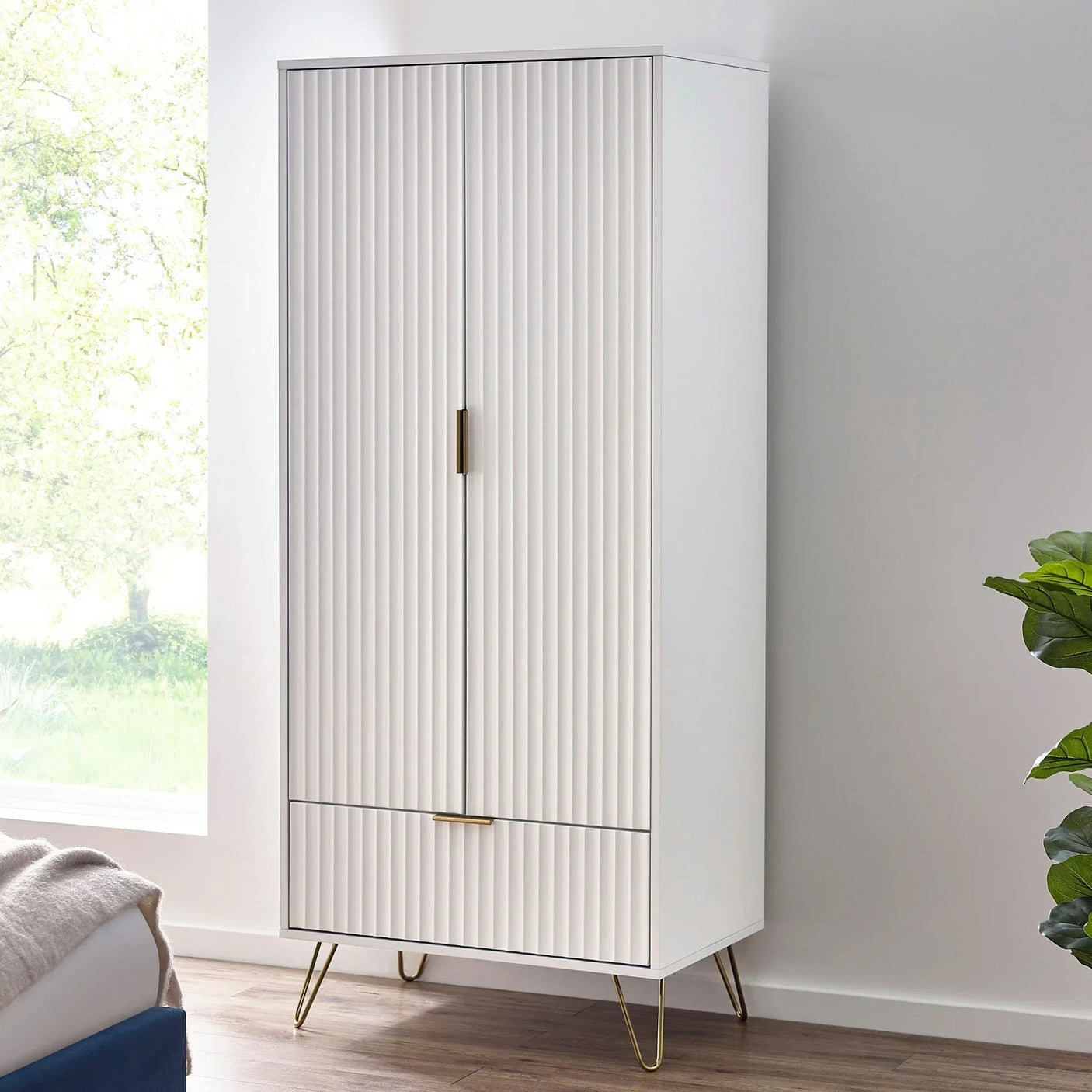 White two door wardrobe with gold handles and legs in modern bedroom