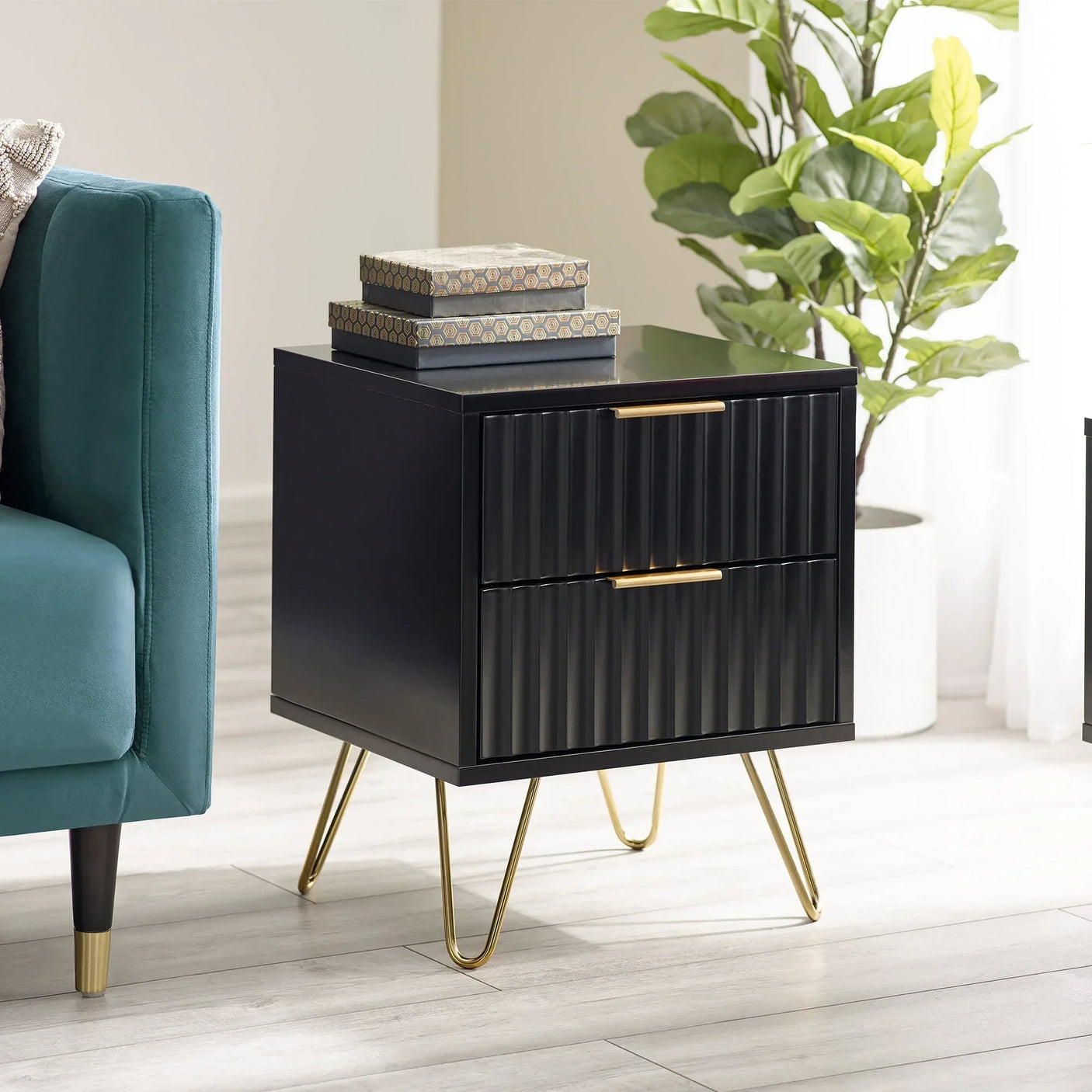 Black bedside table with two ribbed drawers, gold handles, and hairpin legs in modern room