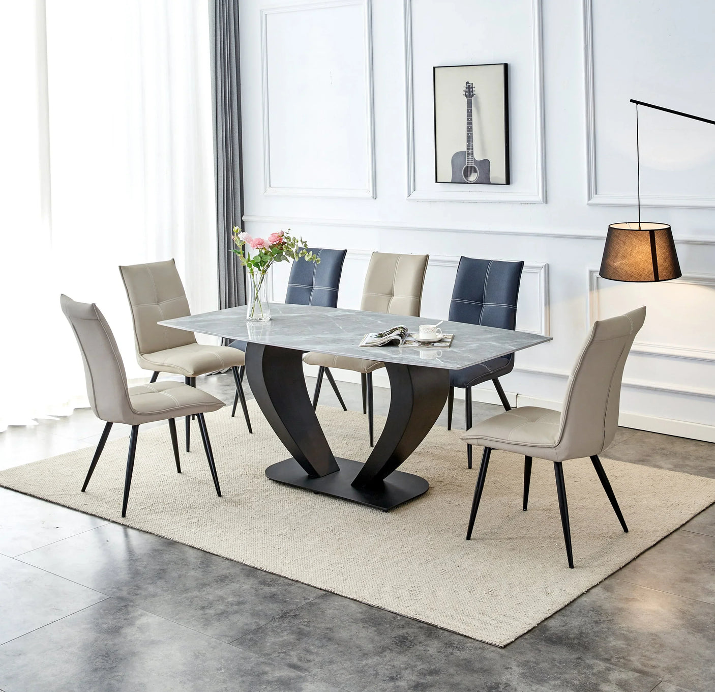 Modern marble-effect dining table with six leather chairs on a neutral rug in bright room