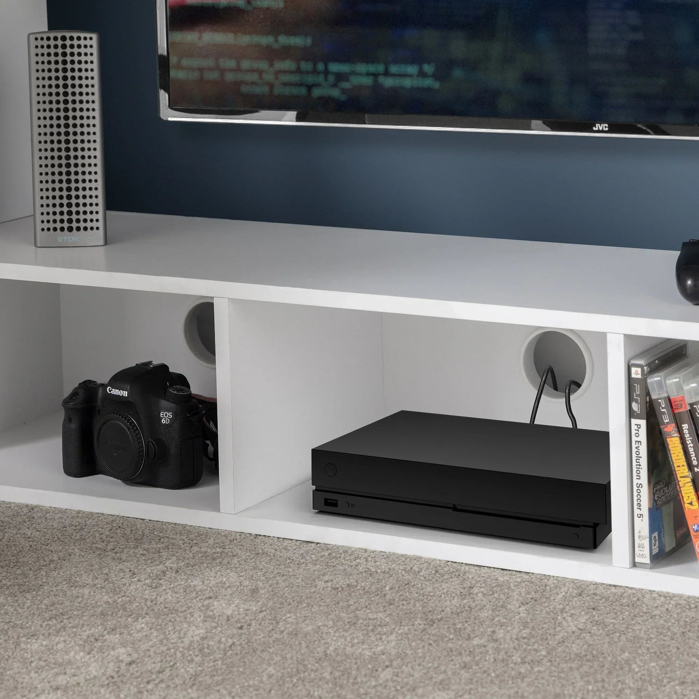 White gaming bunk storage shelf with camera, console, and games under TV unit