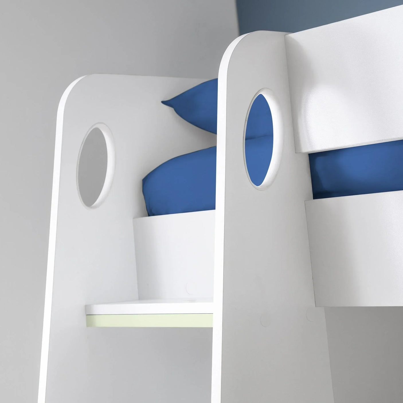White bunk bed ladder detail with circular cut-outs and blue bedding