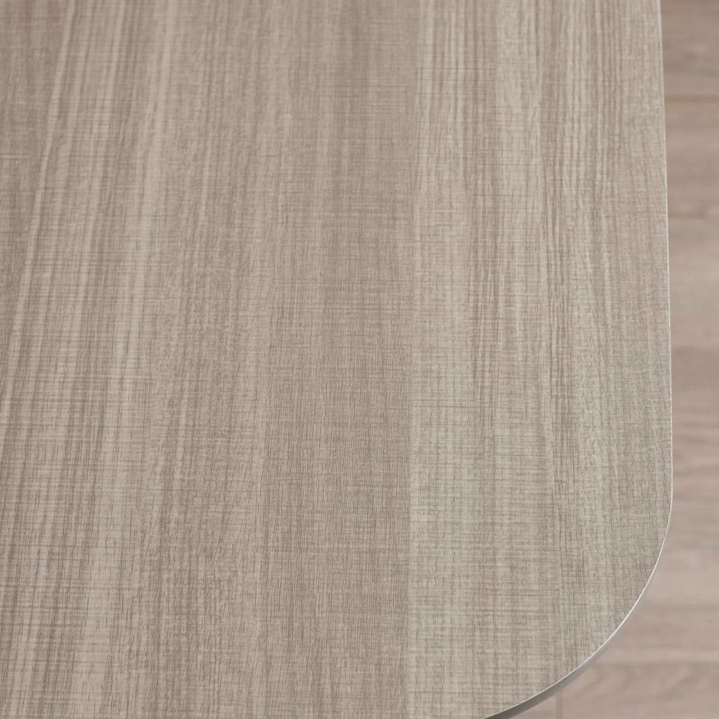 Light wood grain dining table top with rounded edge closeup