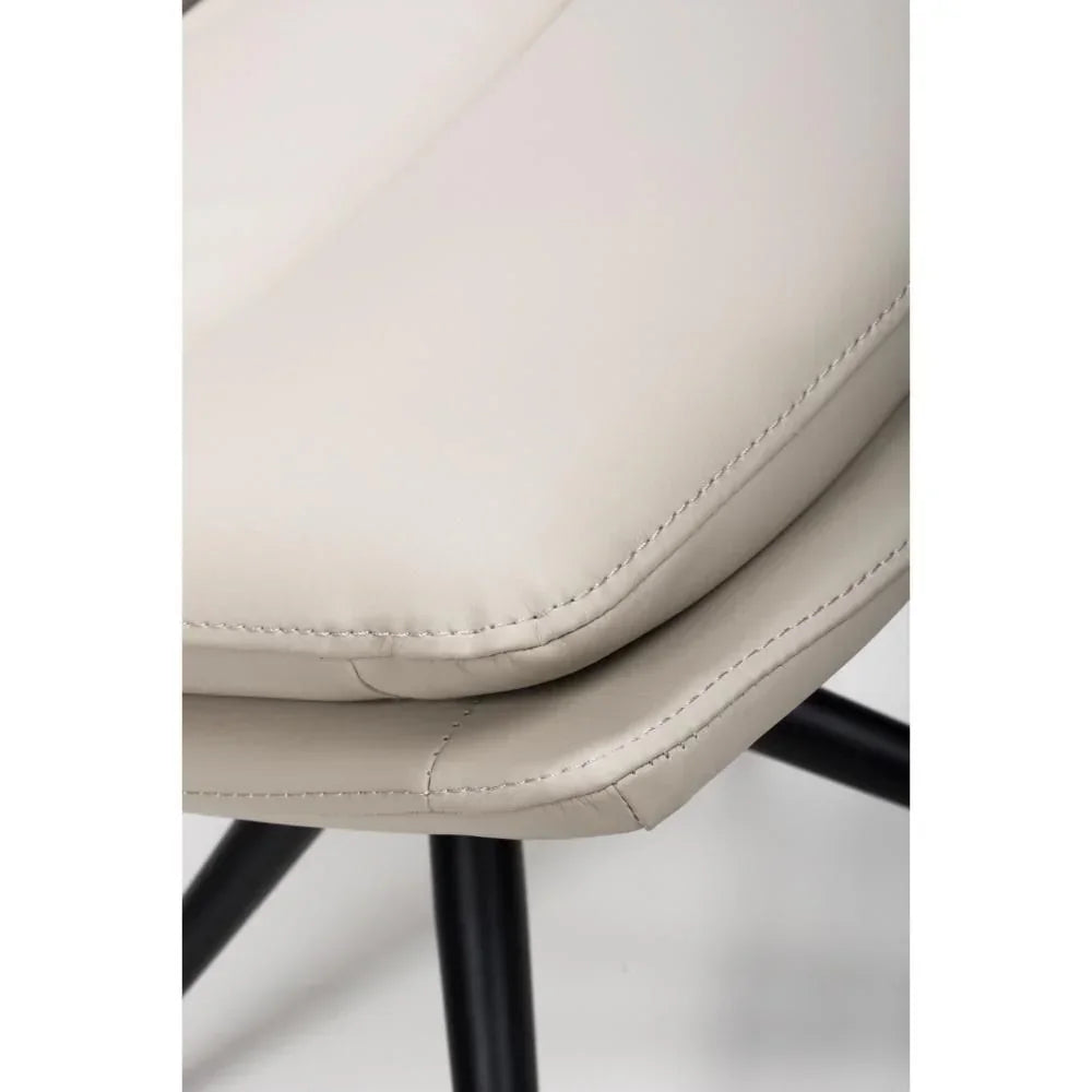 Close-up of beige faux leather dining chair seat with black metal legs