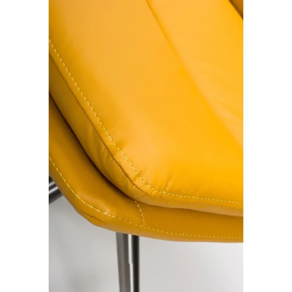 Closeup of yellow leather chair cushion with chrome legs