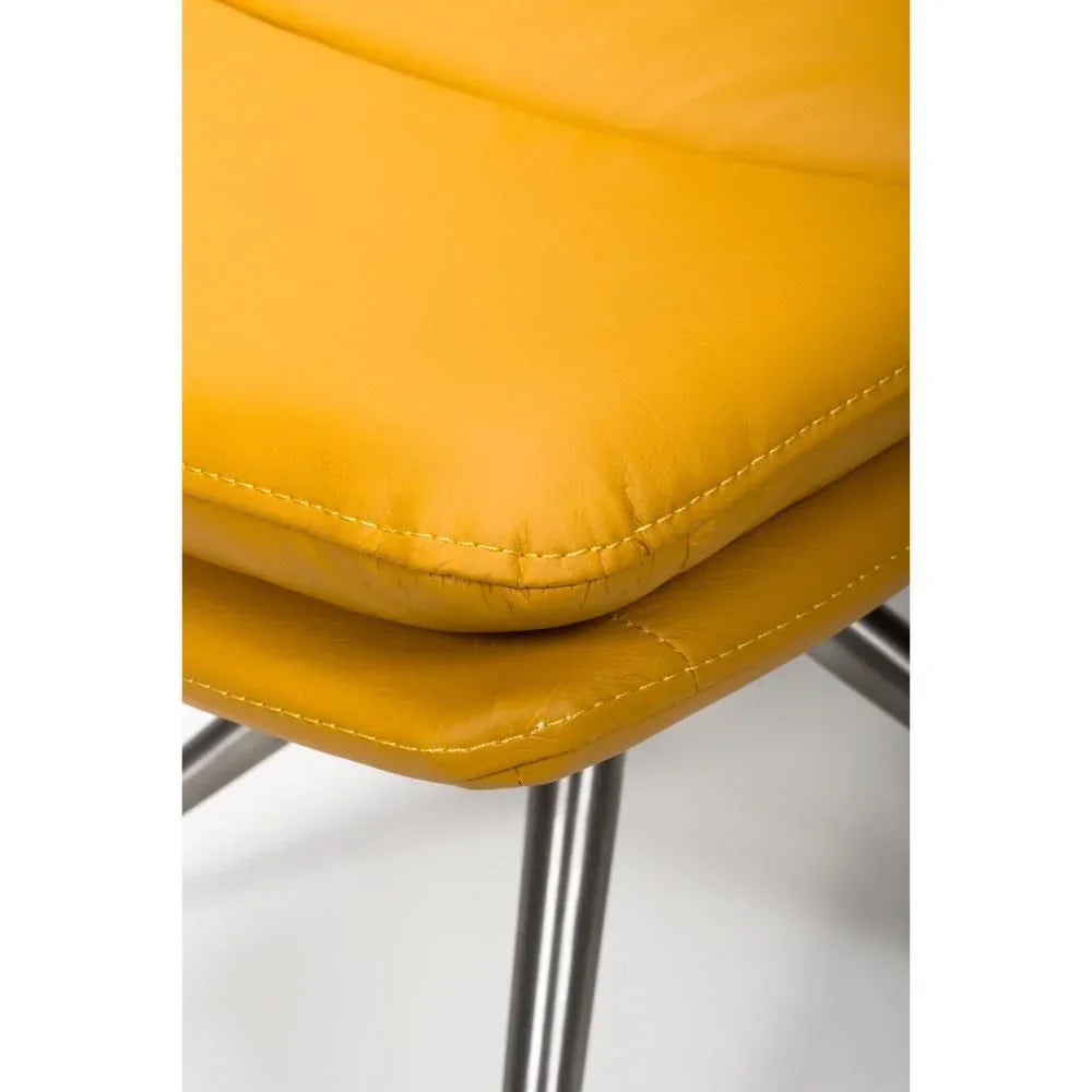 Closeup of yellow leather dining chair seat with chrome legs