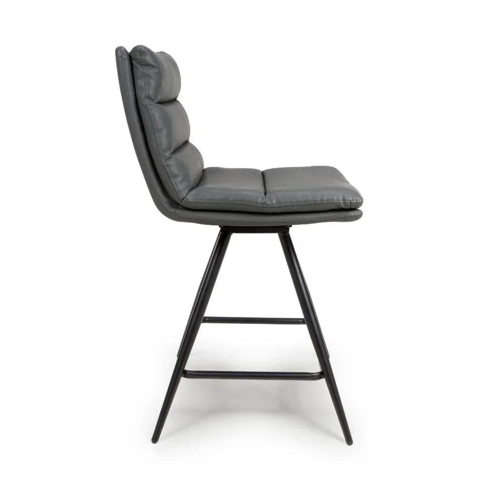 Grey leather bar stool with padded seat and black metal legs side view