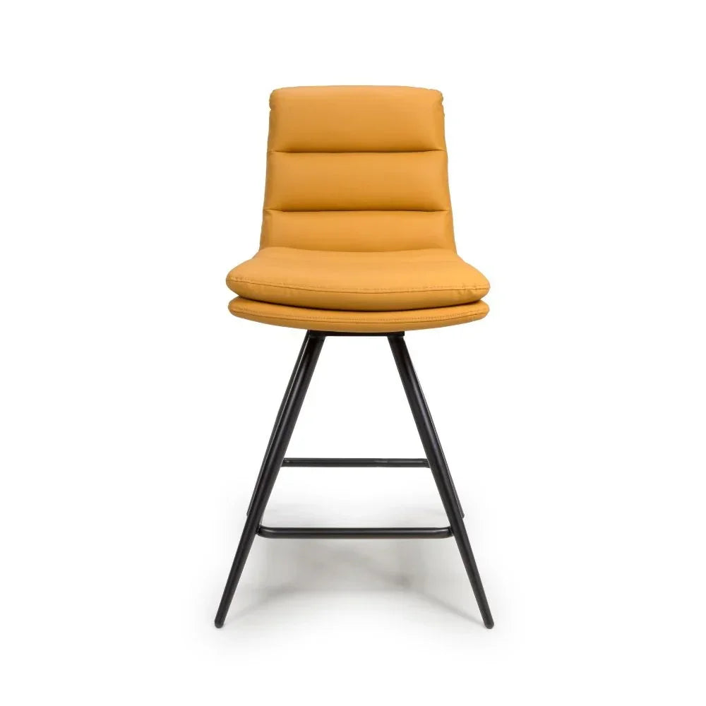 Mustard yellow bar stool with padded seat and black metal legs, front view