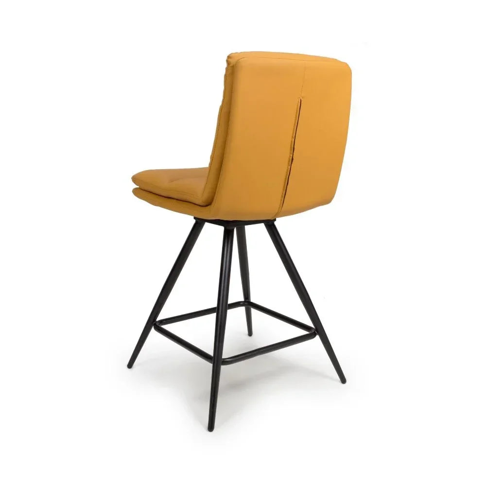 Mustard bar stool with padded backrest and black metal legs, rear angled view