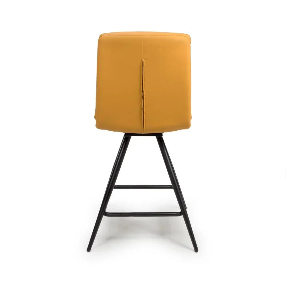 Mustard yellow bar stool with upholstered back and black metal legs, rear view