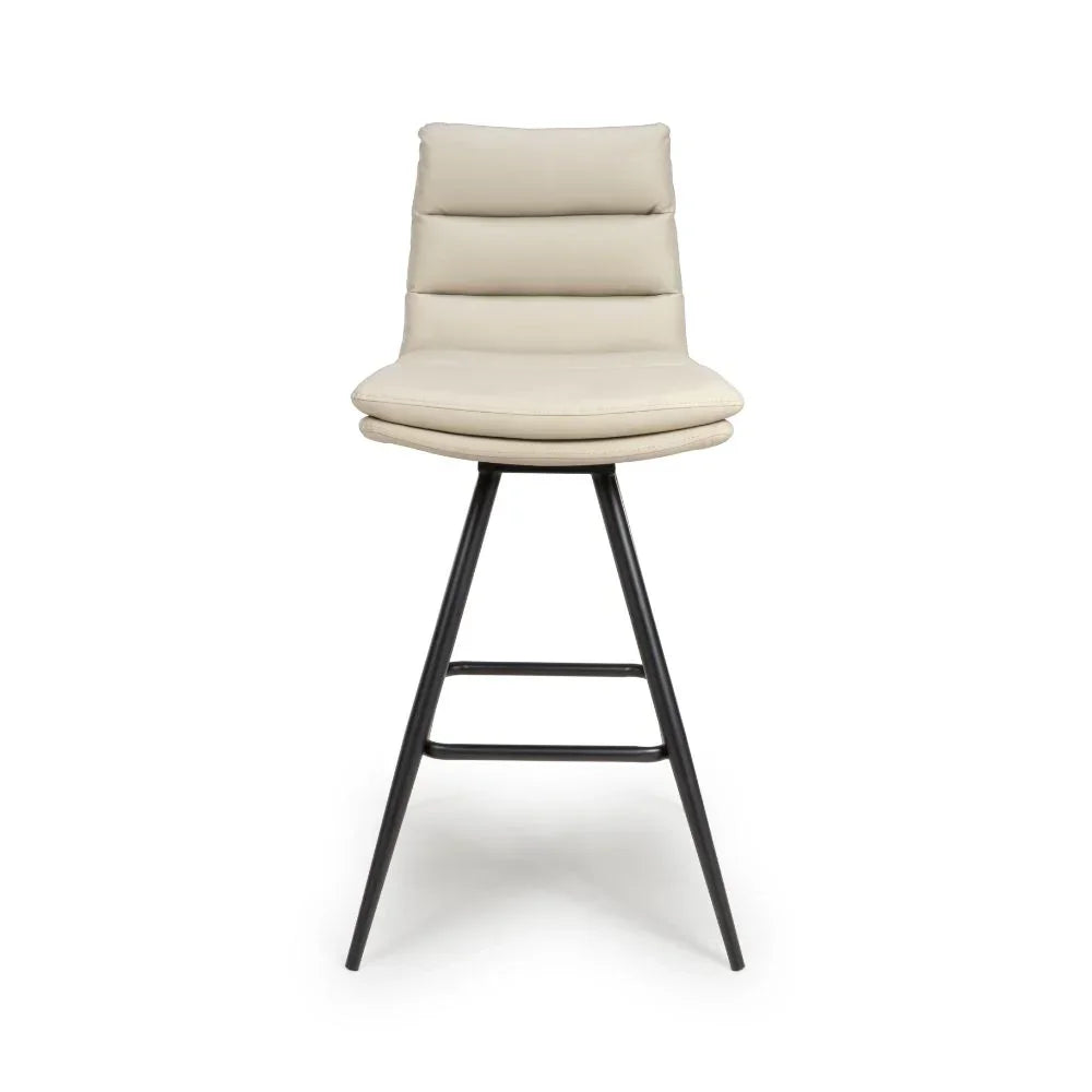 Beige bar stool with padded seat, black angled metal legs, and horizontal stitched backrest