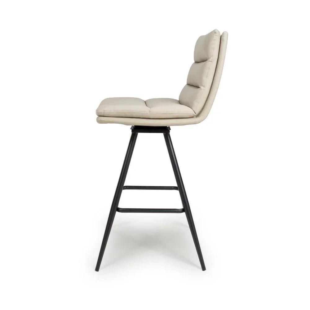 Cream upholstered bar stool with cushioned seat, black metal legs, side profile view