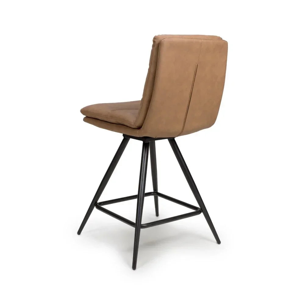 Tan bar stool with padded backrest and black metal legs, rear angled view