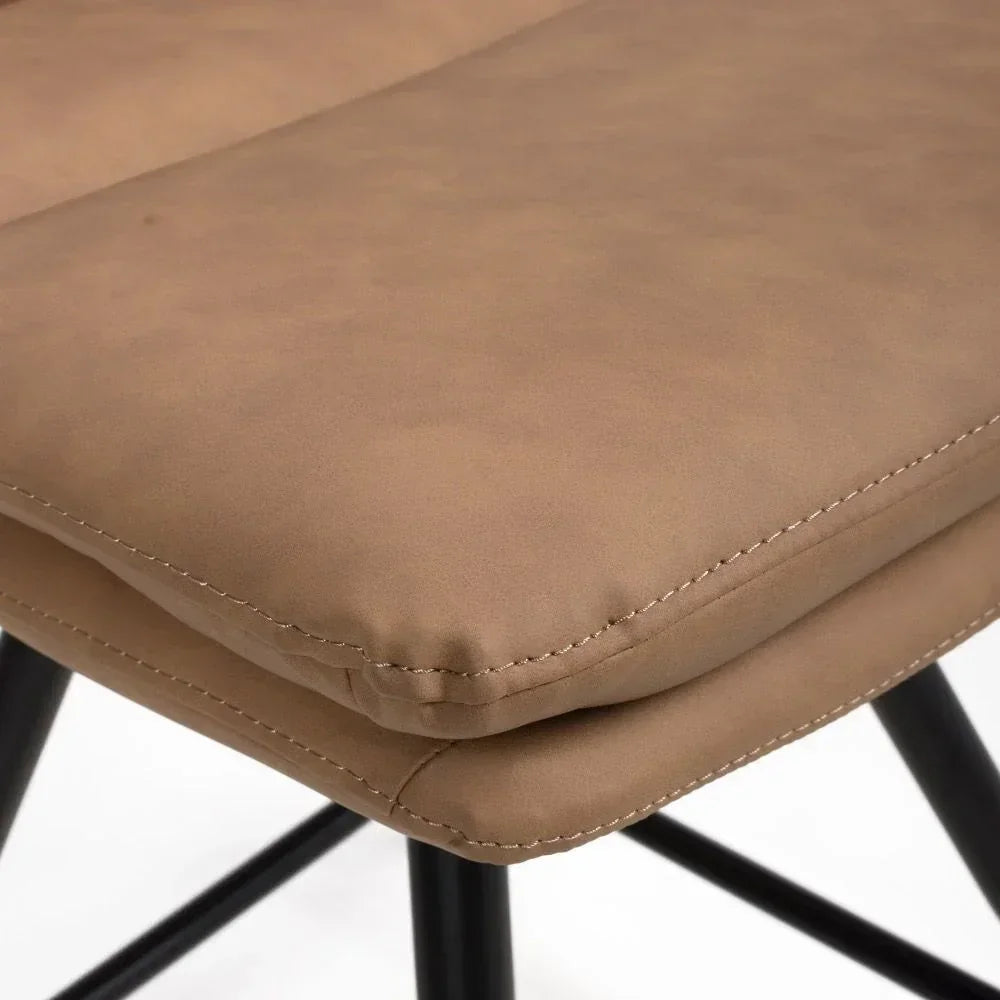 Tan faux leather dining chair seat with visible stitching and black metal legs close-up