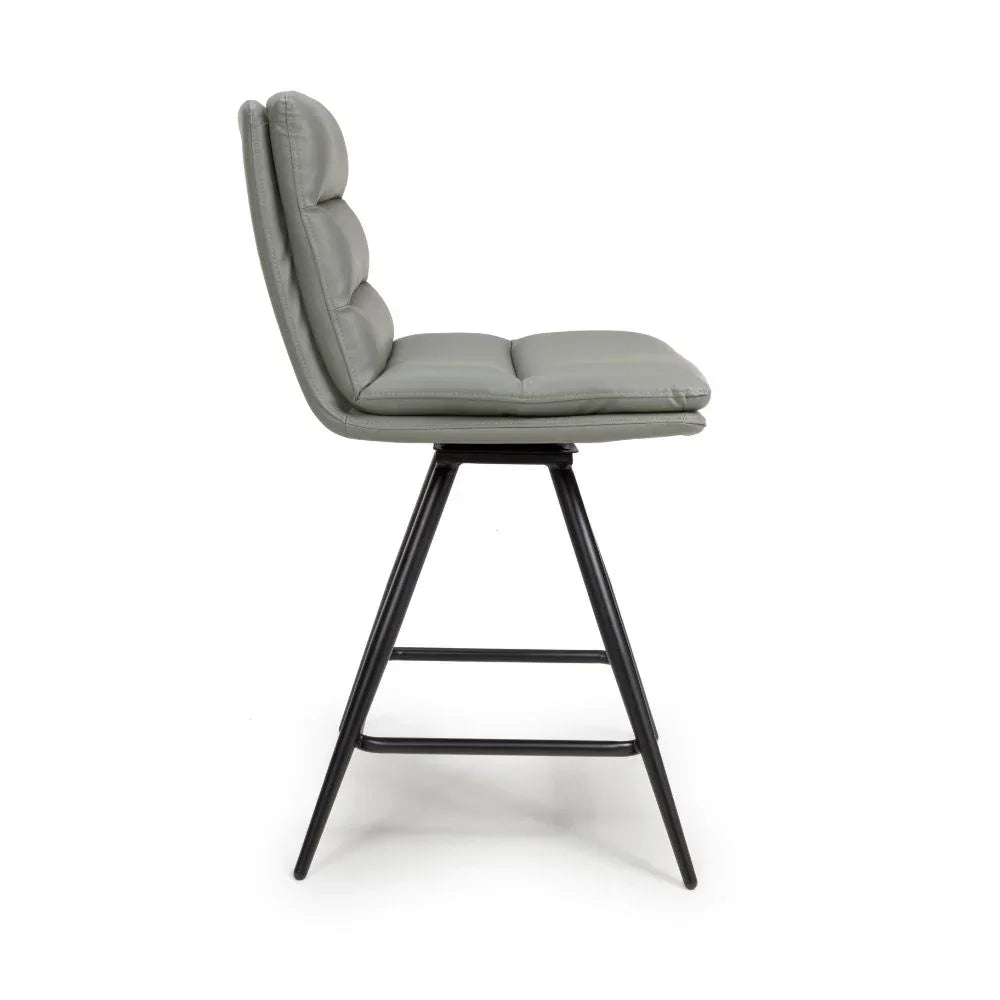 Grey leather bar stool with padded seat and black metal legs side view