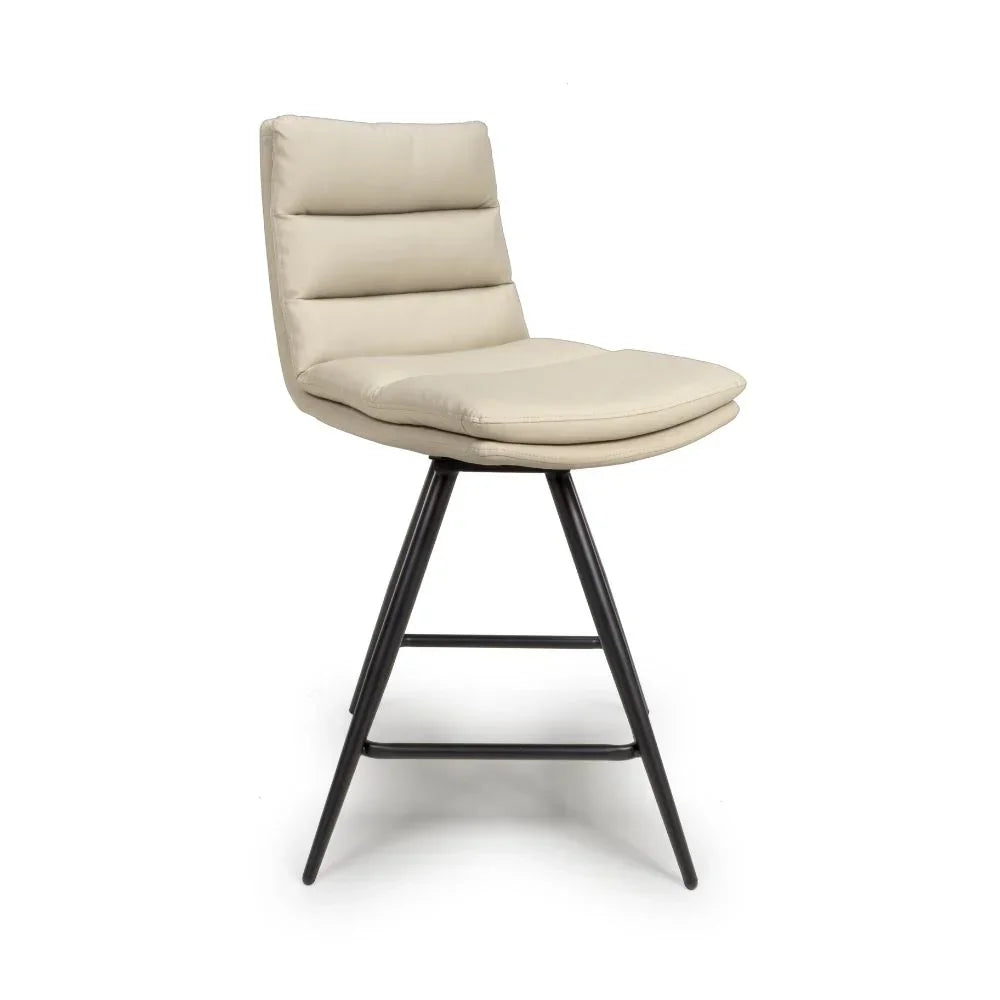 Beige upholstered bar stool with black metal legs and padded seat on white background