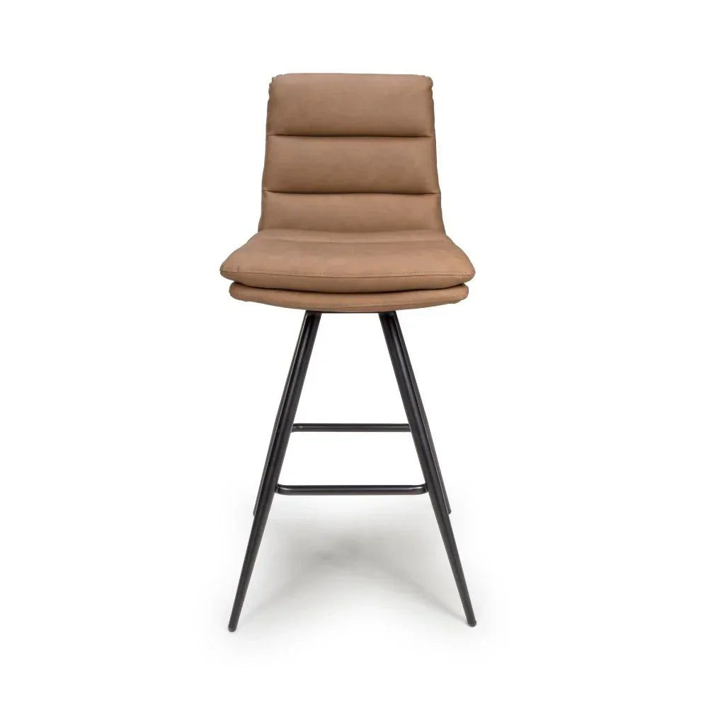 Tan upholstered bar stool with black metal legs, padded seat and horizontal stitched backrest