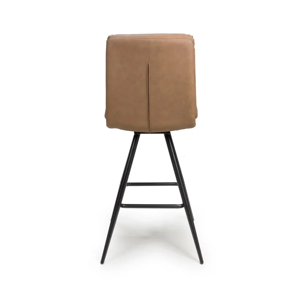 Tan bar stool with faux leather upholstery and black metal legs, rear view