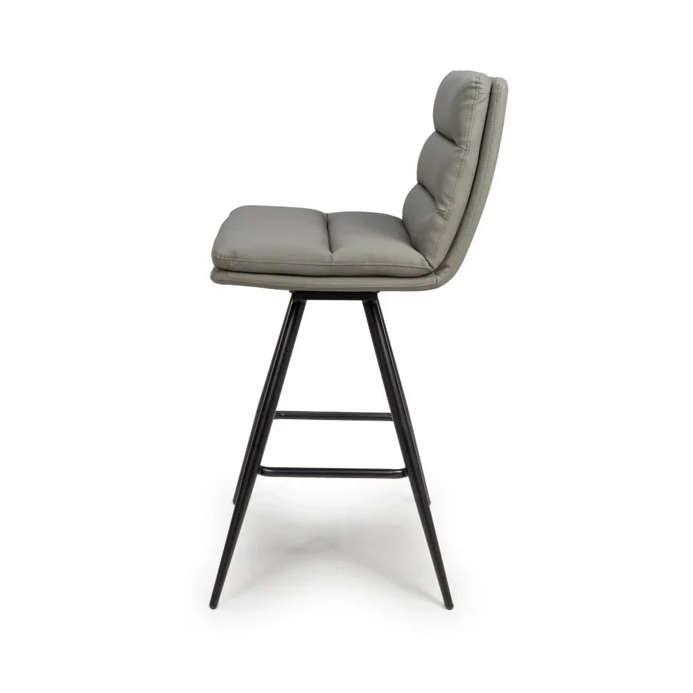 Modern grey bar stool with padded seat, black metal legs, side profile view