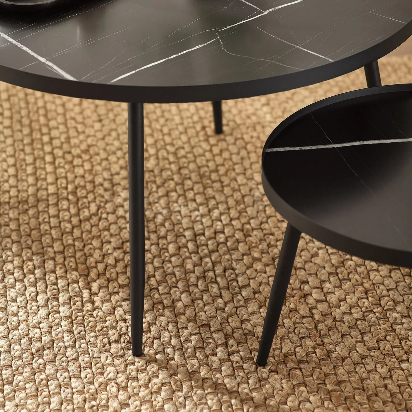 Black marble effect coffee tables with slim metal legs on woven rug