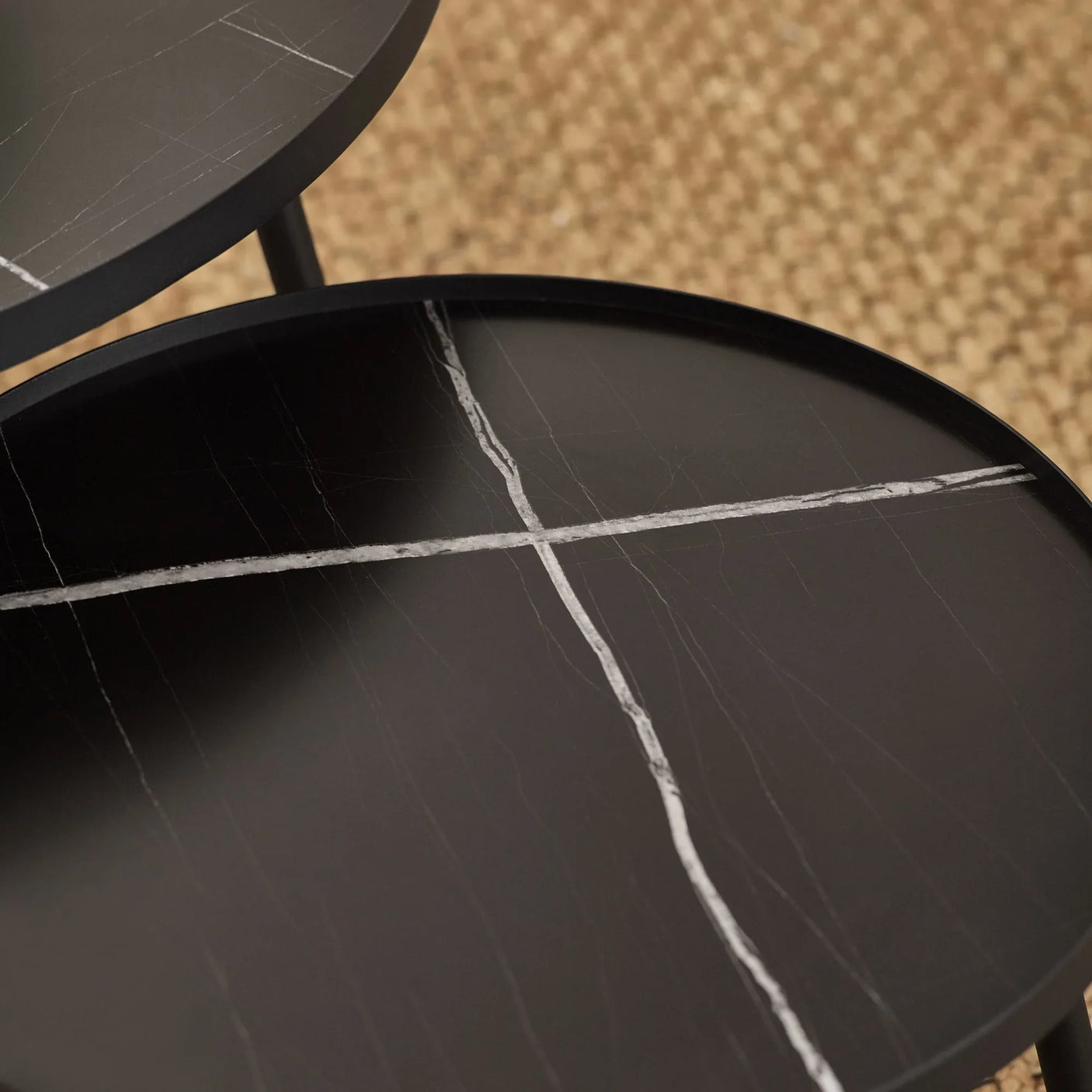 Black marble effect nesting coffee tables with white veining on textured rug