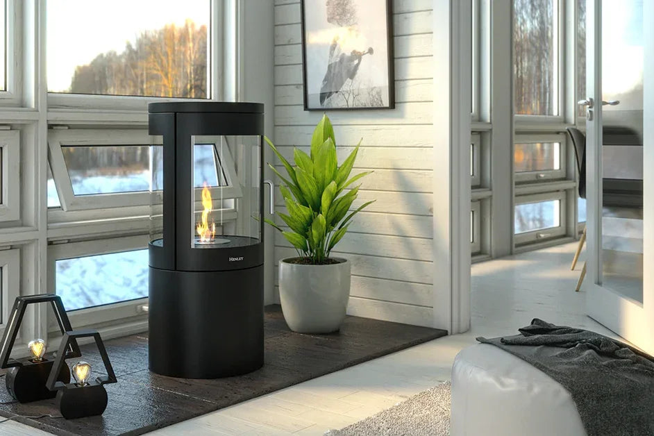 Modern black freestanding stove heater with glass sides in a bright cozy living room corner