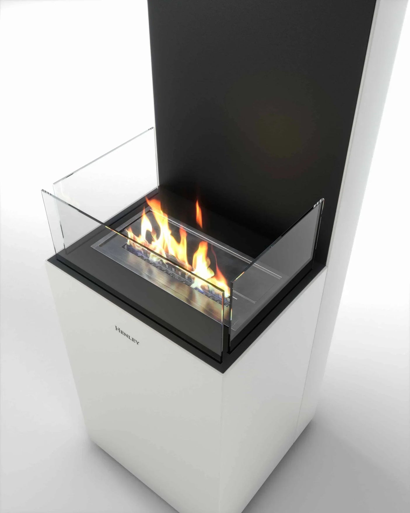 Modern freestanding bioethanol fireplace with glass sides and visible flames, white base