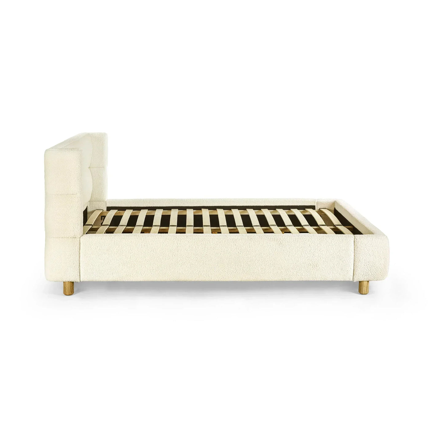 Cream upholstered bed frame with padded headboard and wooden slats, side view
